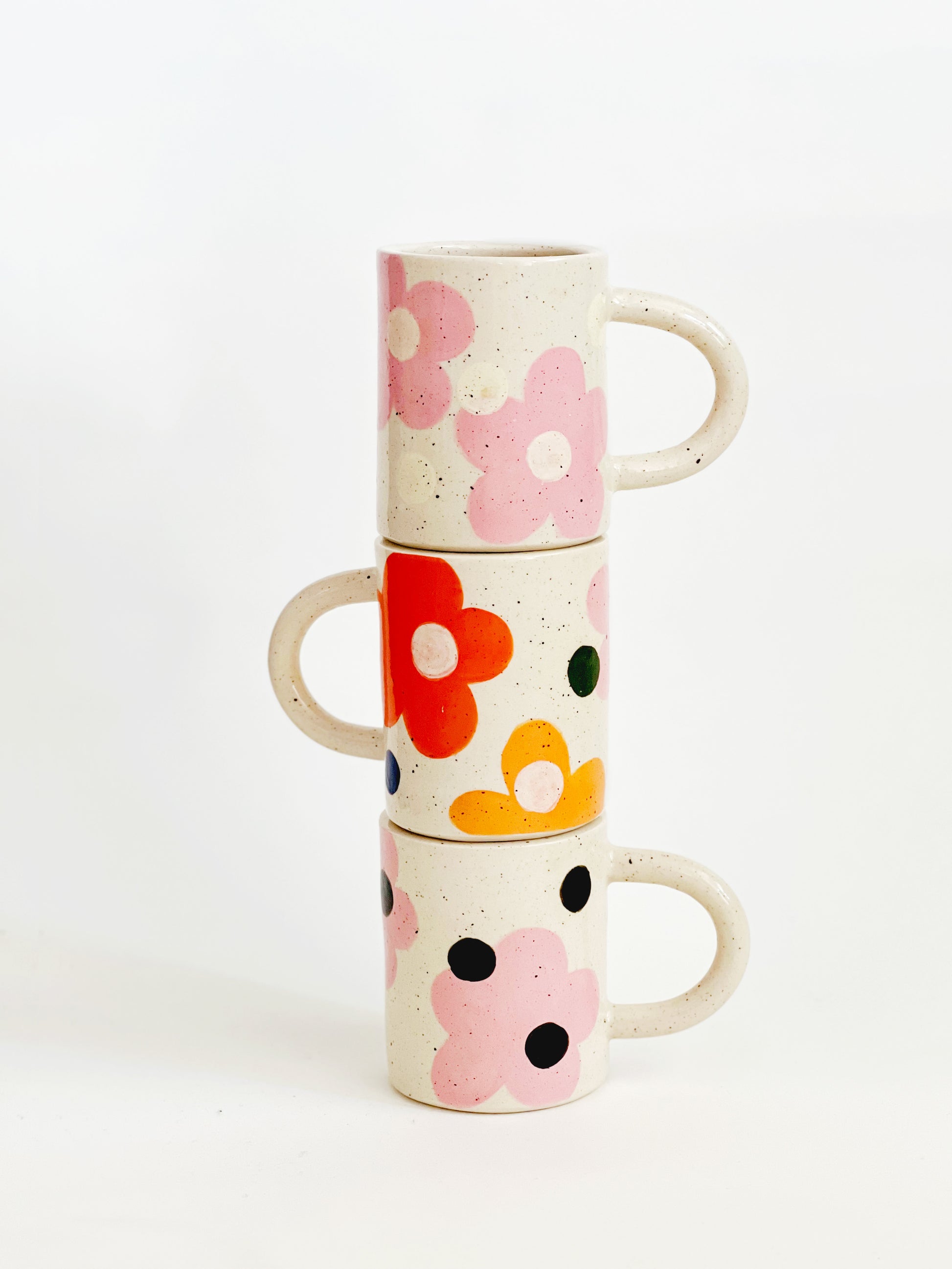 This handmade ceramic mug features a charming design of large dots over delicate flowers, perfect for any flower lover. Made with care and attention to detail, this mug is a beautiful addition to any kitchen. Enjoy your favorite beverage while admiring the intricate artistry of this unique piece. Crafted to bring joy and beauty to your daily routine.