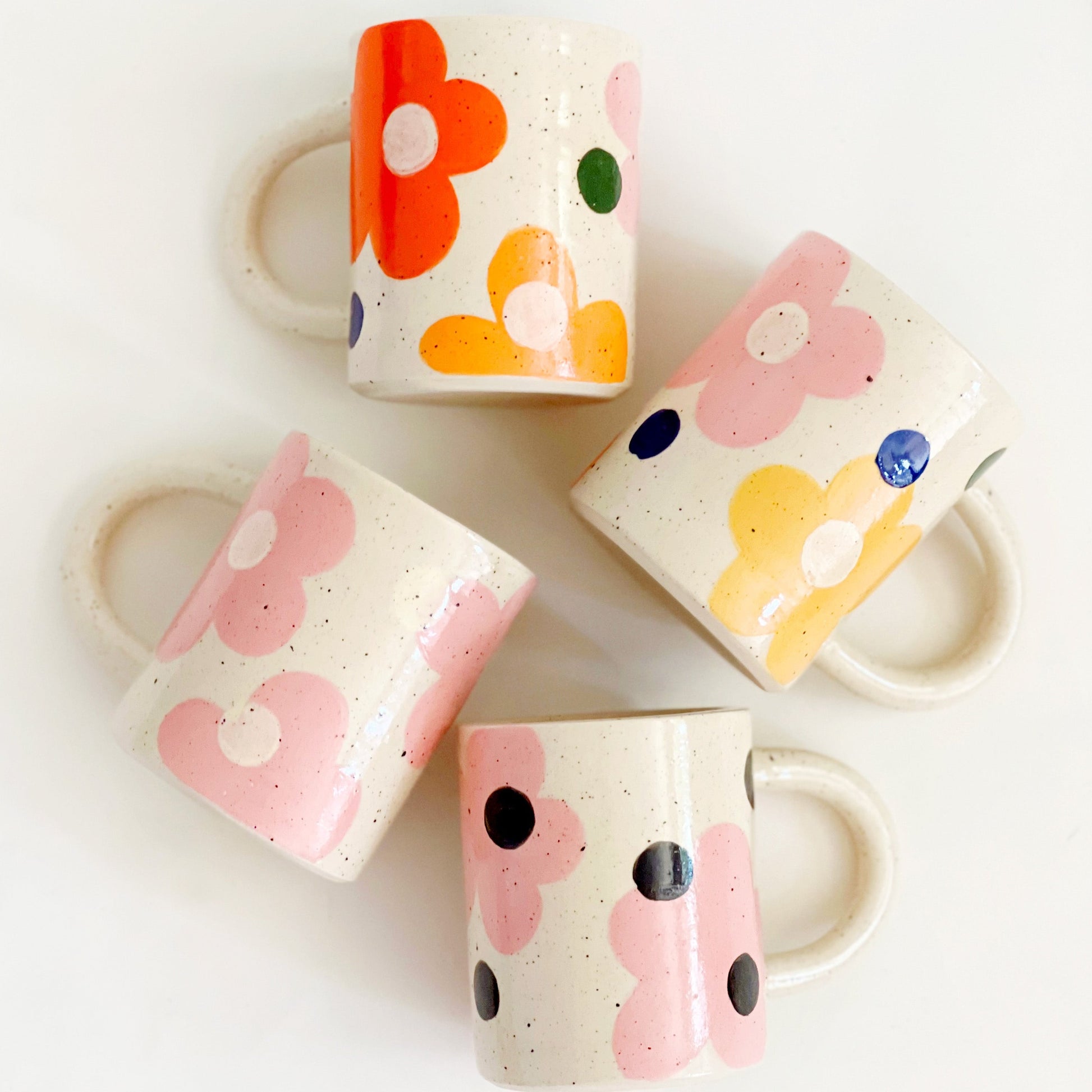 This handmade ceramic mug features a charming design of large dots over delicate flowers, perfect for any flower lover. Made with care and attention to detail, this mug is a beautiful addition to any kitchen. Enjoy your favorite beverage while admiring the intricate artistry of this unique piece. Crafted to bring joy and beauty to your daily routine.