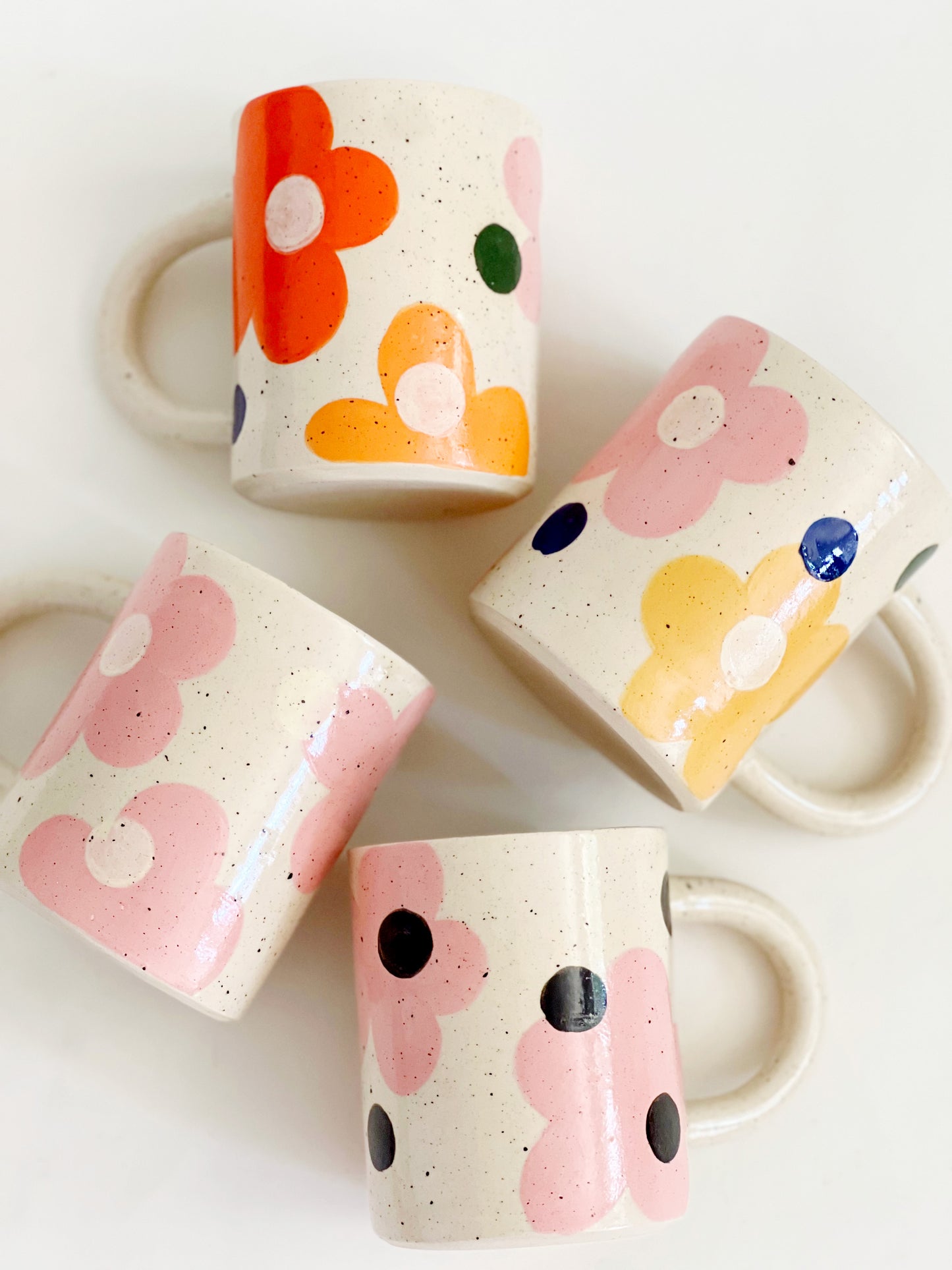 This handmade ceramic mug features a charming design of large dots over delicate flowers, perfect for any flower lover. Made with care and attention to detail, this mug is a beautiful addition to any kitchen. Enjoy your favorite beverage while admiring the intricate artistry of this unique piece. Crafted to bring joy and beauty to your daily routine.