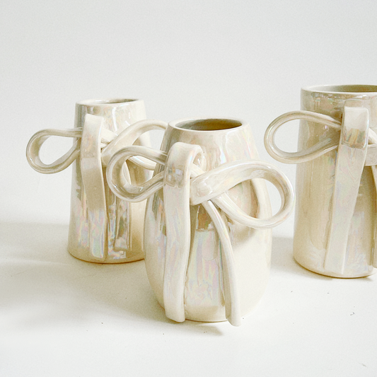 Three ceramic vases with handles on a white background