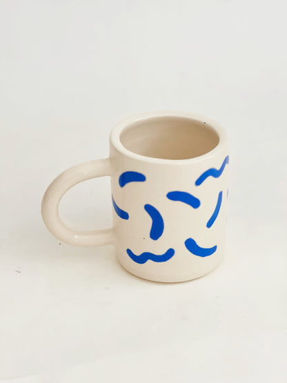 The fun squiggles design adds a touch of whimsy to your cup of coffee or tea. Made by hand, this ceramic mug is durable and perfect for everyday use. Enjoy your favorite beverage in style with our unique Squiggles Mug.