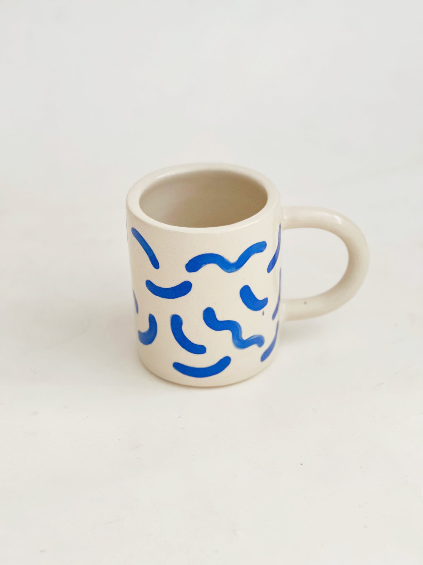 The fun squiggles design adds a touch of whimsy to your cup of coffee or tea. Made by hand, this ceramic mug is durable and perfect for everyday use. Enjoy your favorite beverage in style with our unique Squiggles Mug.