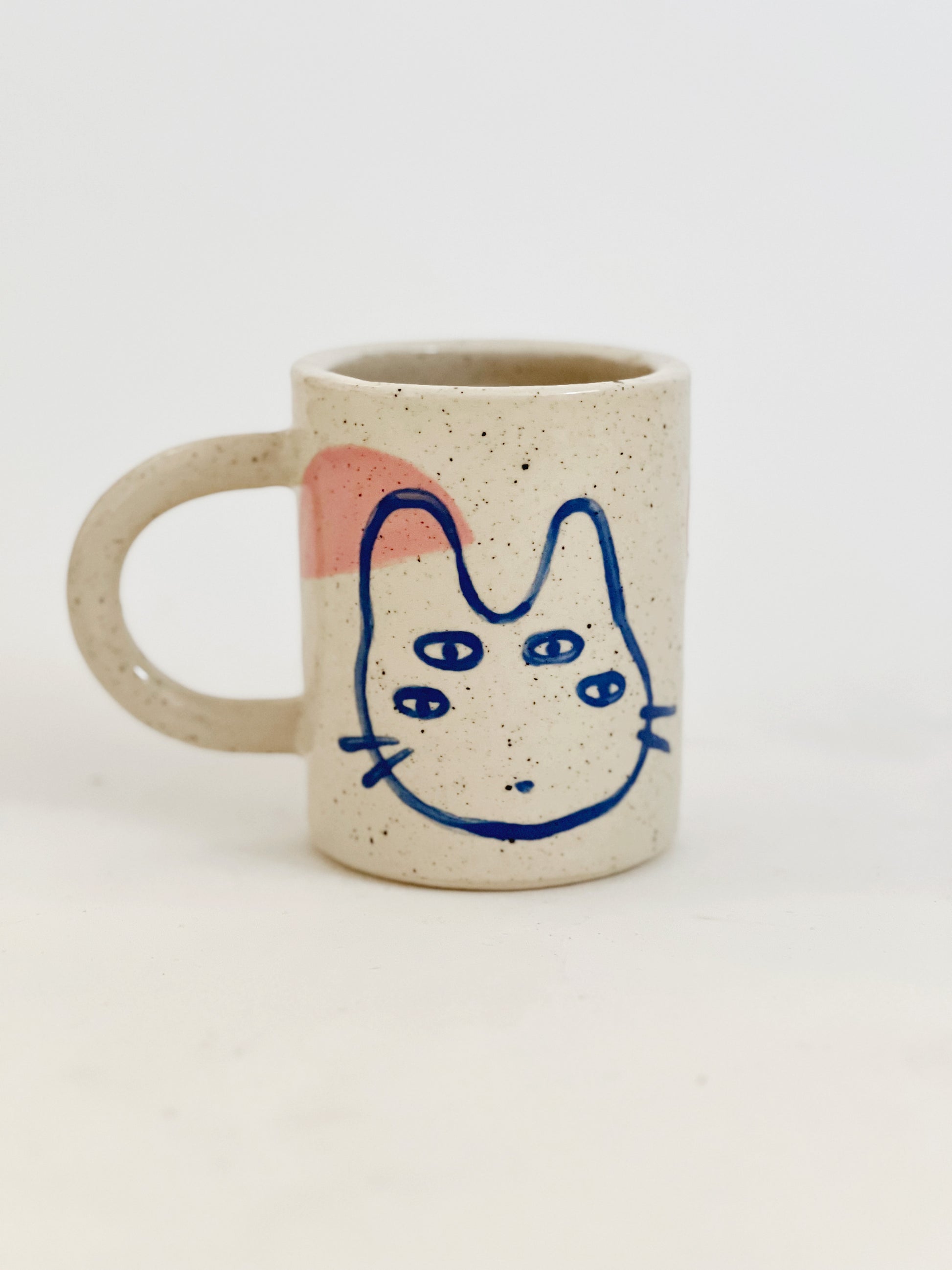 Introducing our Large Little Four Eyes Handmade Ceramic Mug, featuring our signature design inspired by our adorable and beloved pet, Bowl. This cute and unique mug is perfect for pet lovers. Handcrafted with care, it's the perfect addition to your morning routine. Brighten up your day with every sip!