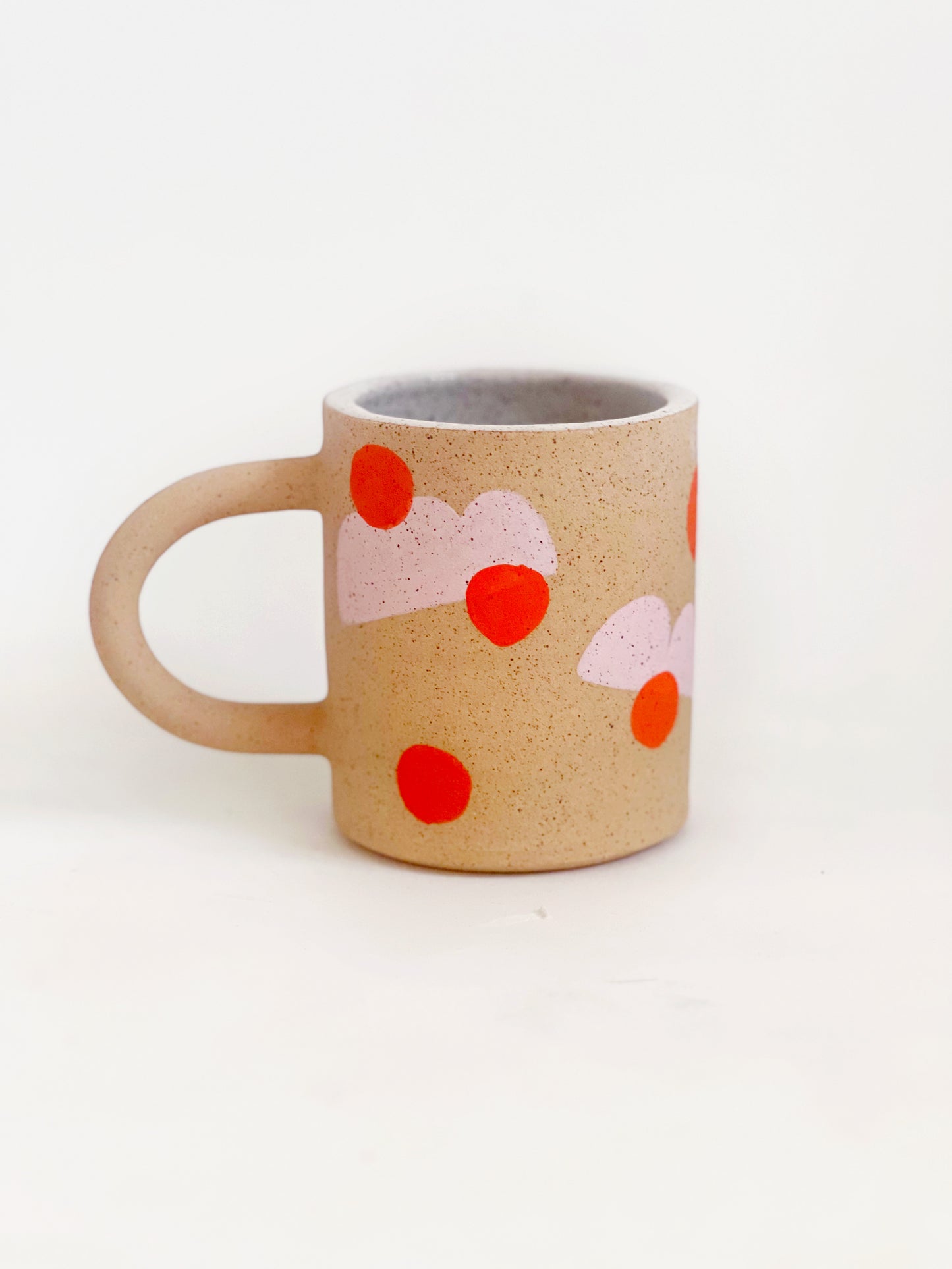 This handmade ceramic mug features playful polka dots over different shapes, adding a colorful and fun touch to your daily coffee or tea routine. Handcrafted with attention to detail, this unique mug is a must-have for any ceramic collection. Enjoy your favorite drink in a playful yet elegant way.