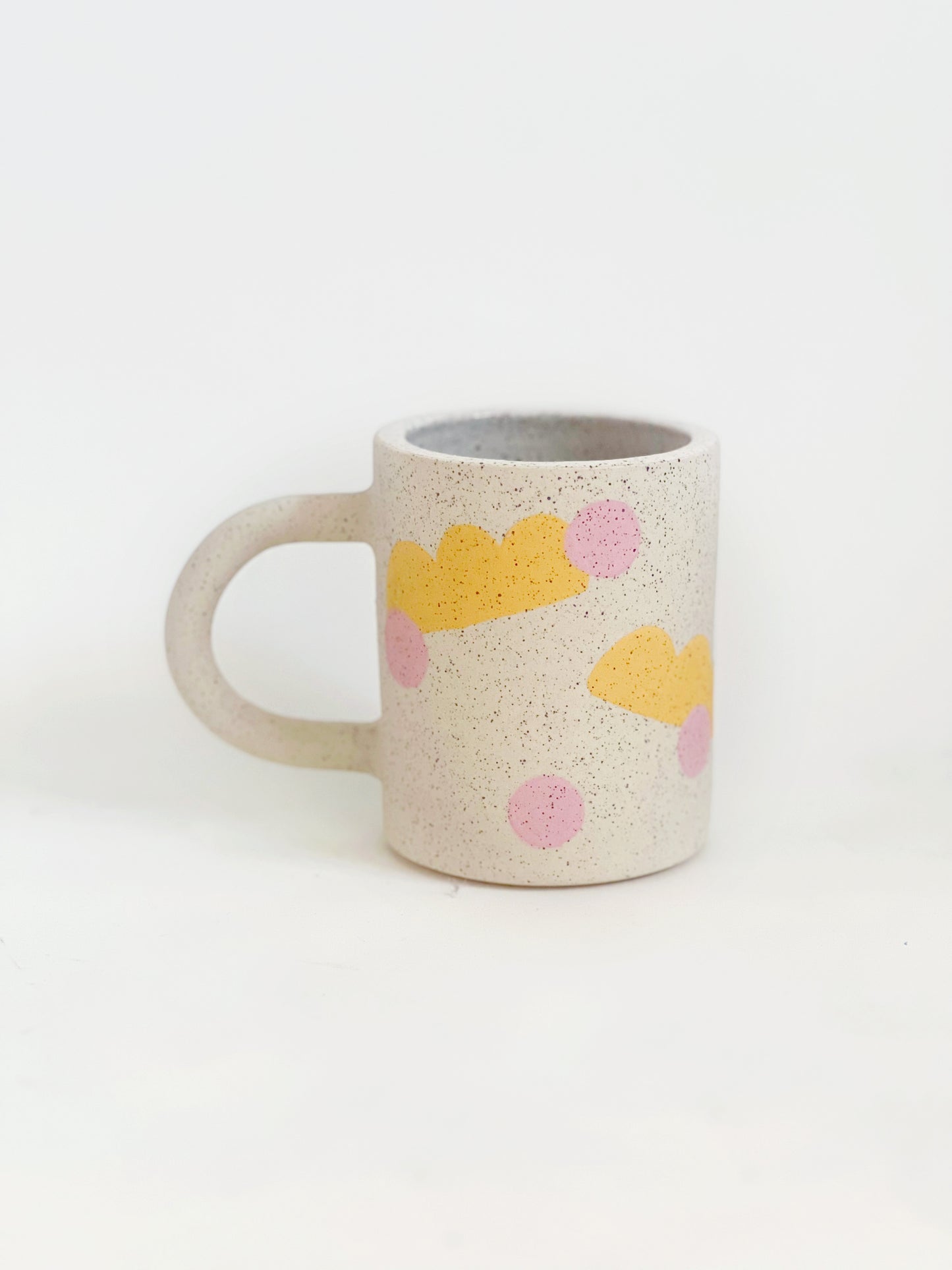 This handmade ceramic mug features playful polka dots over different shapes, adding a colorful and fun touch to your daily coffee or tea routine. Handcrafted with attention to detail, this unique mug is a must-have for any ceramic collection. Enjoy your favorite drink in a playful yet elegant way.