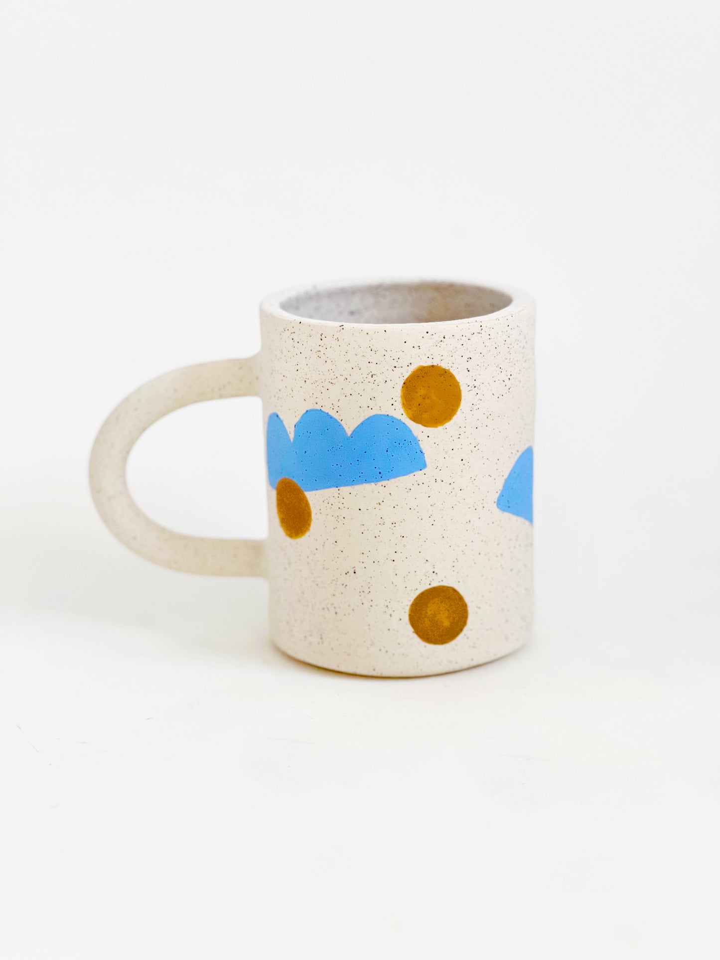 This handmade ceramic mug features playful polka dots over different shapes, adding a colorful and fun touch to your daily coffee or tea routine. Handcrafted with attention to detail, this unique mug is a must-have for any ceramic collection. Enjoy your favorite drink in a playful yet elegant way.