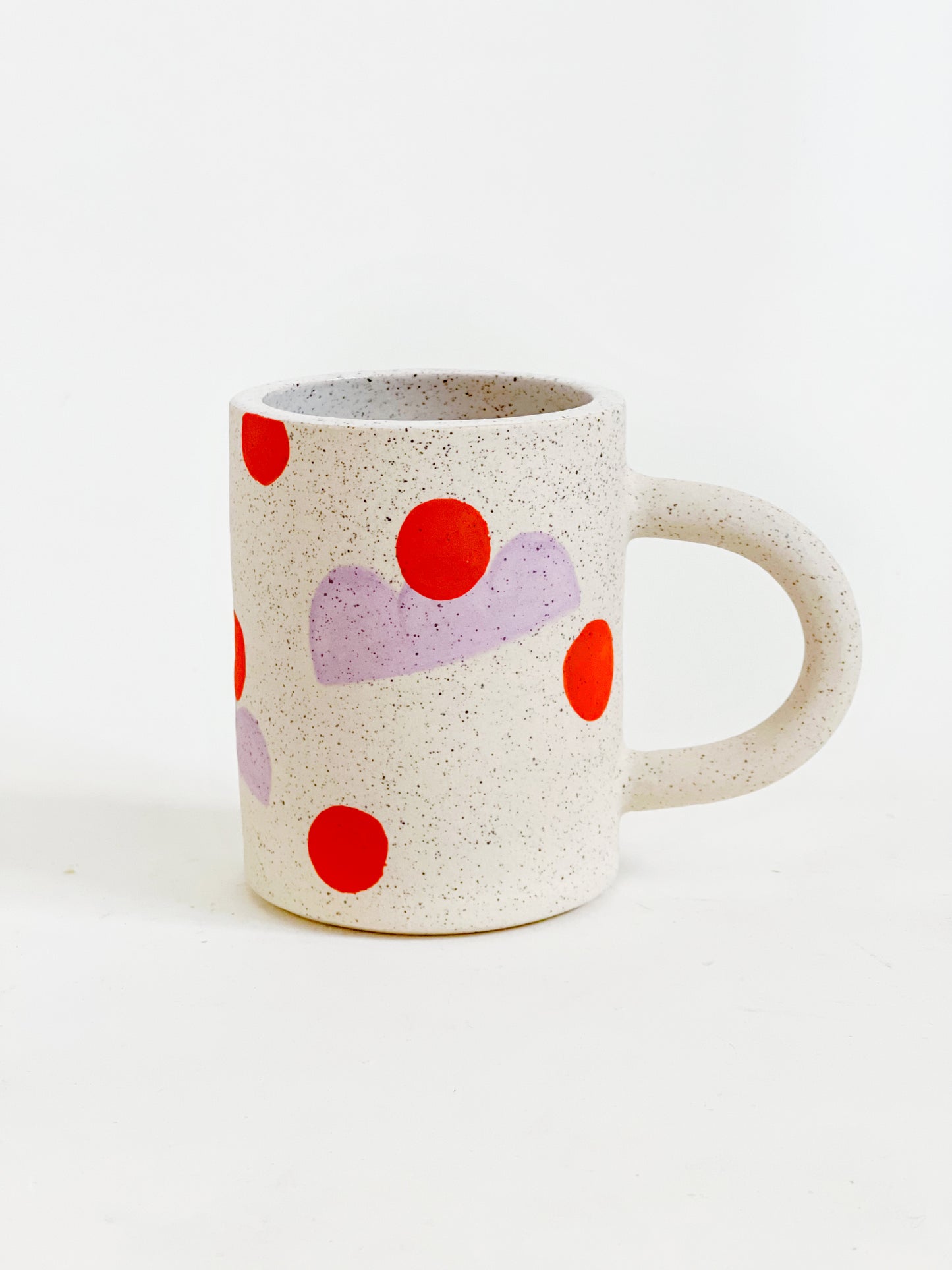 This handmade ceramic mug features playful polka dots over different shapes, adding a colorful and fun touch to your daily coffee or tea routine. Handcrafted with attention to detail, this unique mug is a must-have for any ceramic collection. Enjoy your favorite drink in a playful yet elegant way.