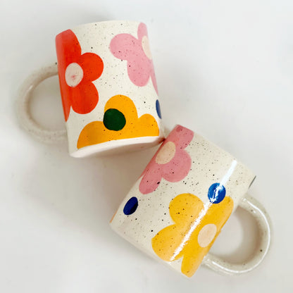 This handmade ceramic mug features a charming design of large dots over delicate flowers, perfect for any flower lover. Made with care and attention to detail, this mug is a beautiful addition to any kitchen. Enjoy your favorite beverage while admiring the intricate artistry of this unique piece. Crafted to bring joy and beauty to your daily routine.