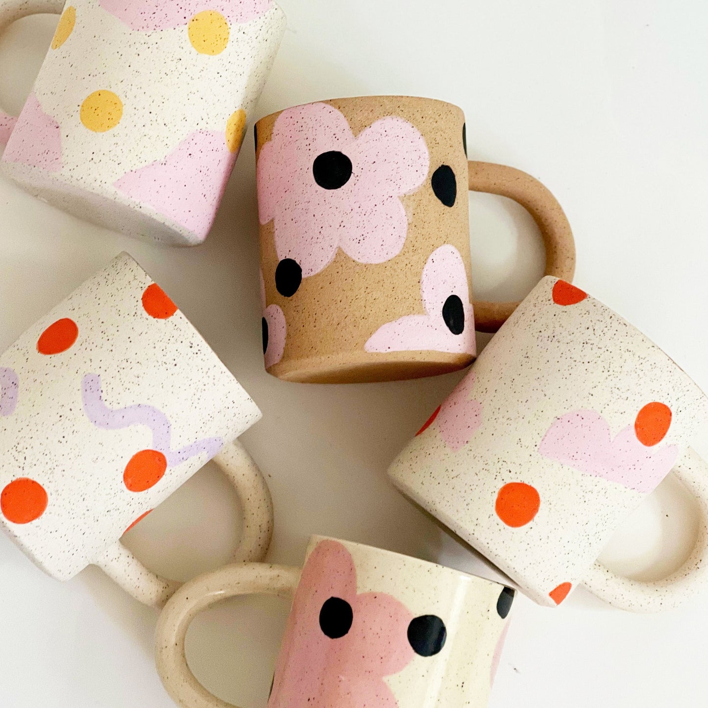 This handmade ceramic mug features playful polka dots over different shapes, adding a colorful and fun touch to your daily coffee or tea routine. Handcrafted with attention to detail, this unique mug is a must-have for any ceramic collection. Enjoy your favorite drink in a playful yet elegant way.