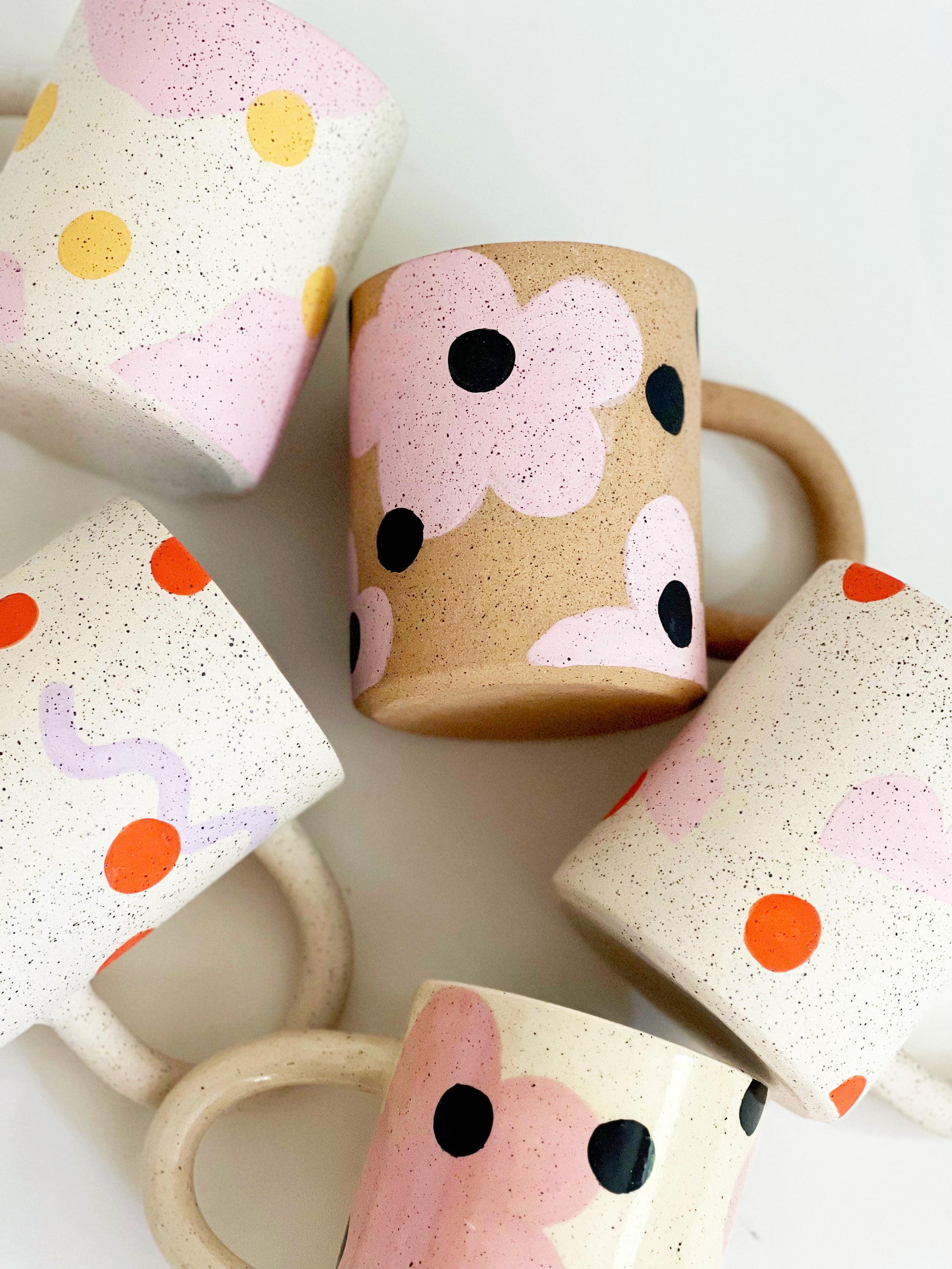 This handmade ceramic mug features playful polka dots over different shapes, adding a colorful and fun touch to your daily coffee or tea routine. Handcrafted with attention to detail, this unique mug is a must-have for any ceramic collection. Enjoy your favorite drink in a playful yet elegant way.