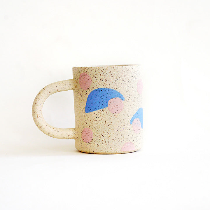 This handmade ceramic mug features playful polka dots over different shapes, adding a colorful and fun touch to your daily coffee or tea routine. Handcrafted with attention to detail, this unique mug is a must-have for any ceramic collection. Enjoy your favorite drink in a playful yet elegant way.